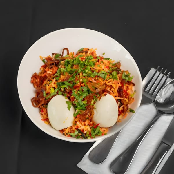 Zaika Indian Bistro Bar's flavorful biryani with two hard-boiled eggs, garnished with fresh cilantro.