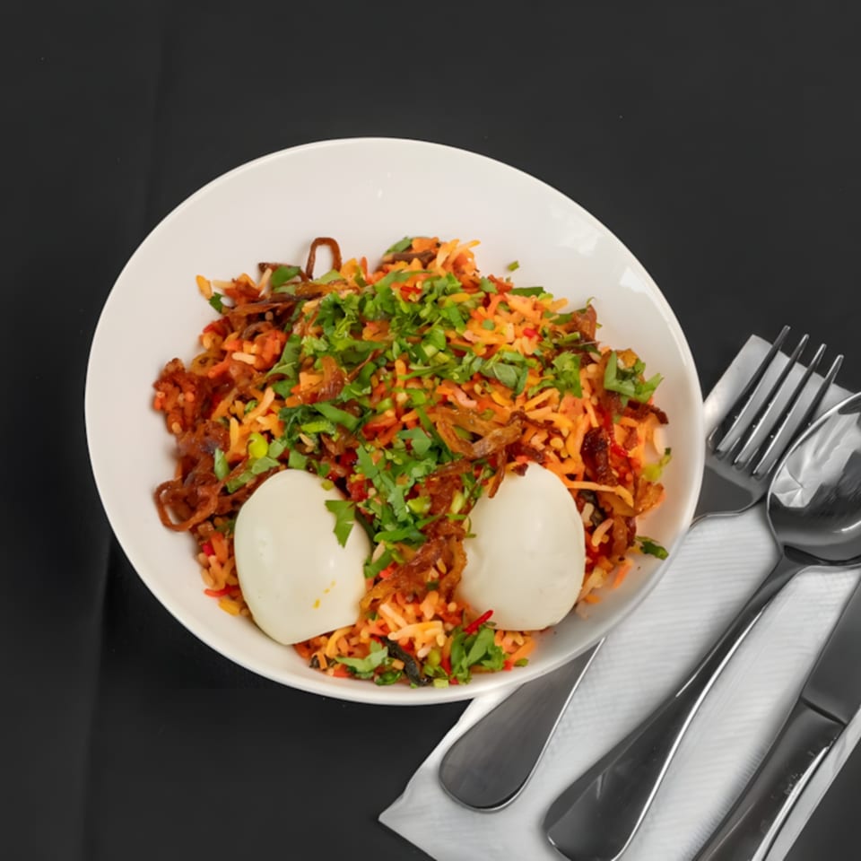 Zaika Indian Bistro Bar's flavorful biryani with two hard-boiled eggs, garnished with fresh cilantro.