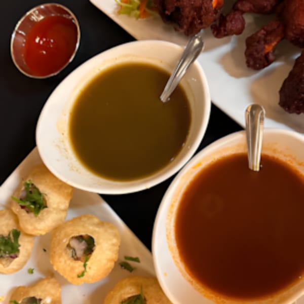 Zaika Indian Bistro Bar's Pani Puri with two dipping sauces and chicken lollipops.