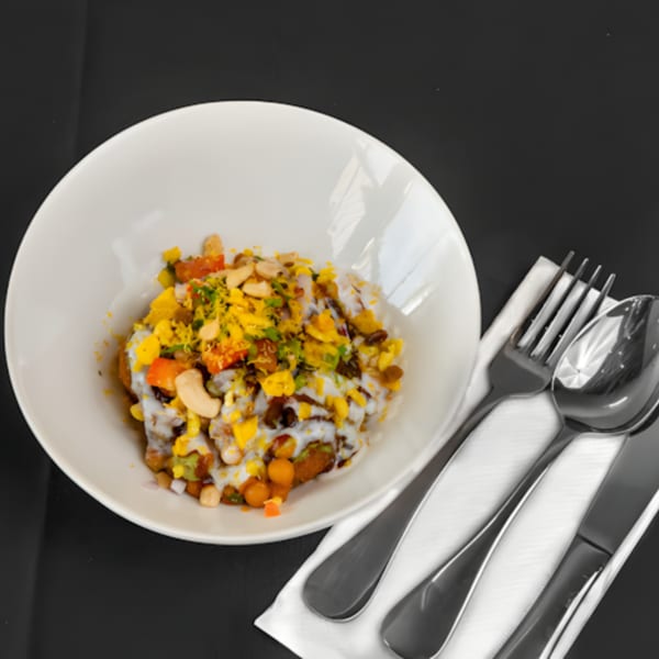 Zaika Indian Bistro Bar's colorful Indian chaat with yogurt, nuts, and spices in a white bowl.