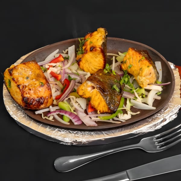 Zaika Indian Bistro Bar's salmon tikka, served sizzling on a platter with onions and peppers.